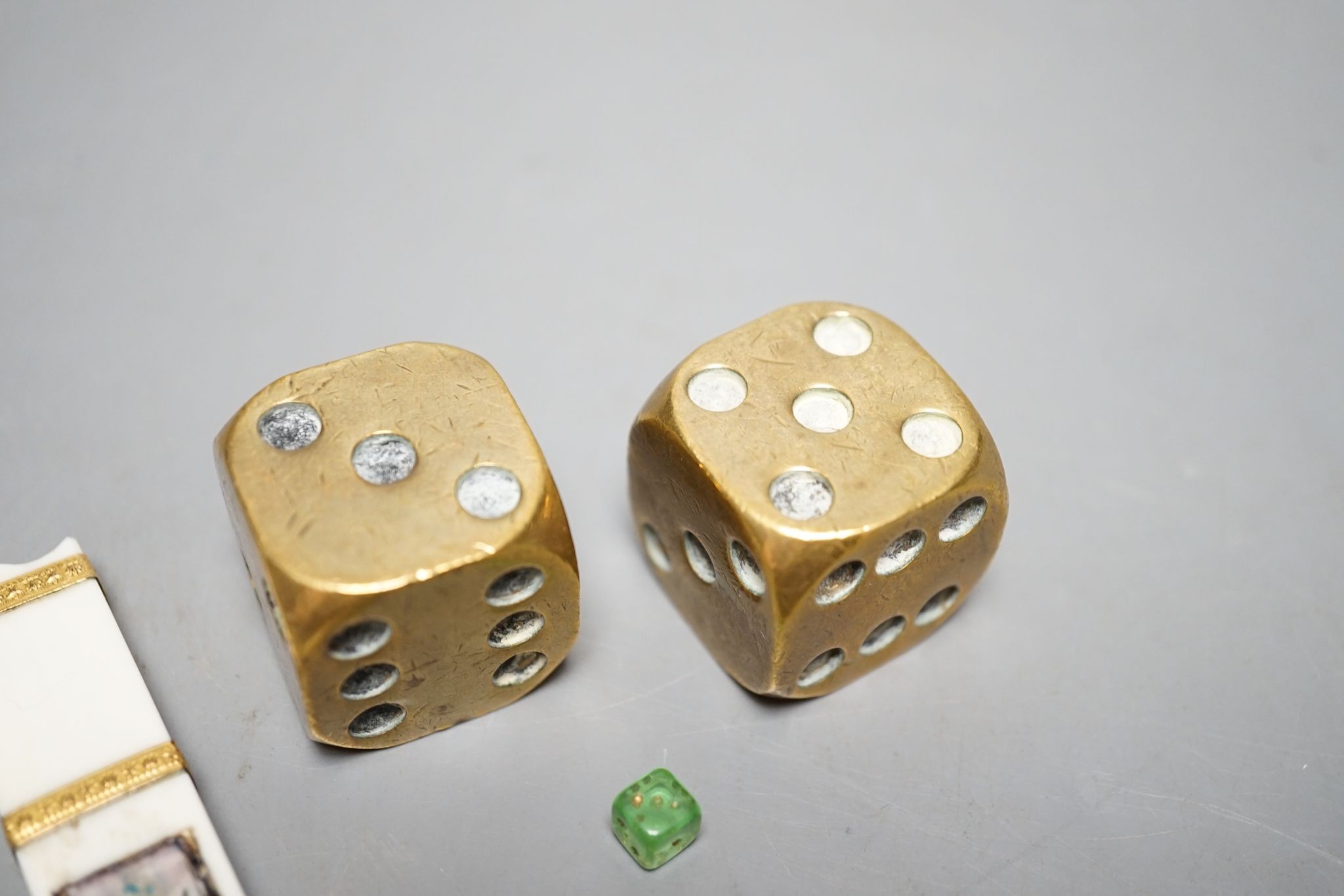 A late 18th century ivory and gold mounted needle case, two brass dice and three mini dice